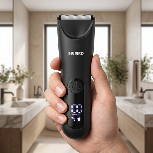 best way to remove body hair for men in Singapore, a matte black Blubird Trim Reaper body trimmer held in one hand in a bright modern bathroom, BLUBIRD wordmark visible on the body