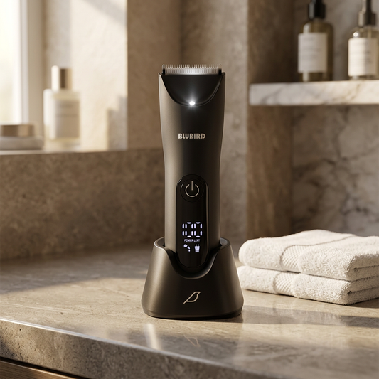 how to trim armpit hair for men, a black Blubird Trim Reaper body trimmer standing in its charging dock on a warm-lit bathroom counter beside a folded towel